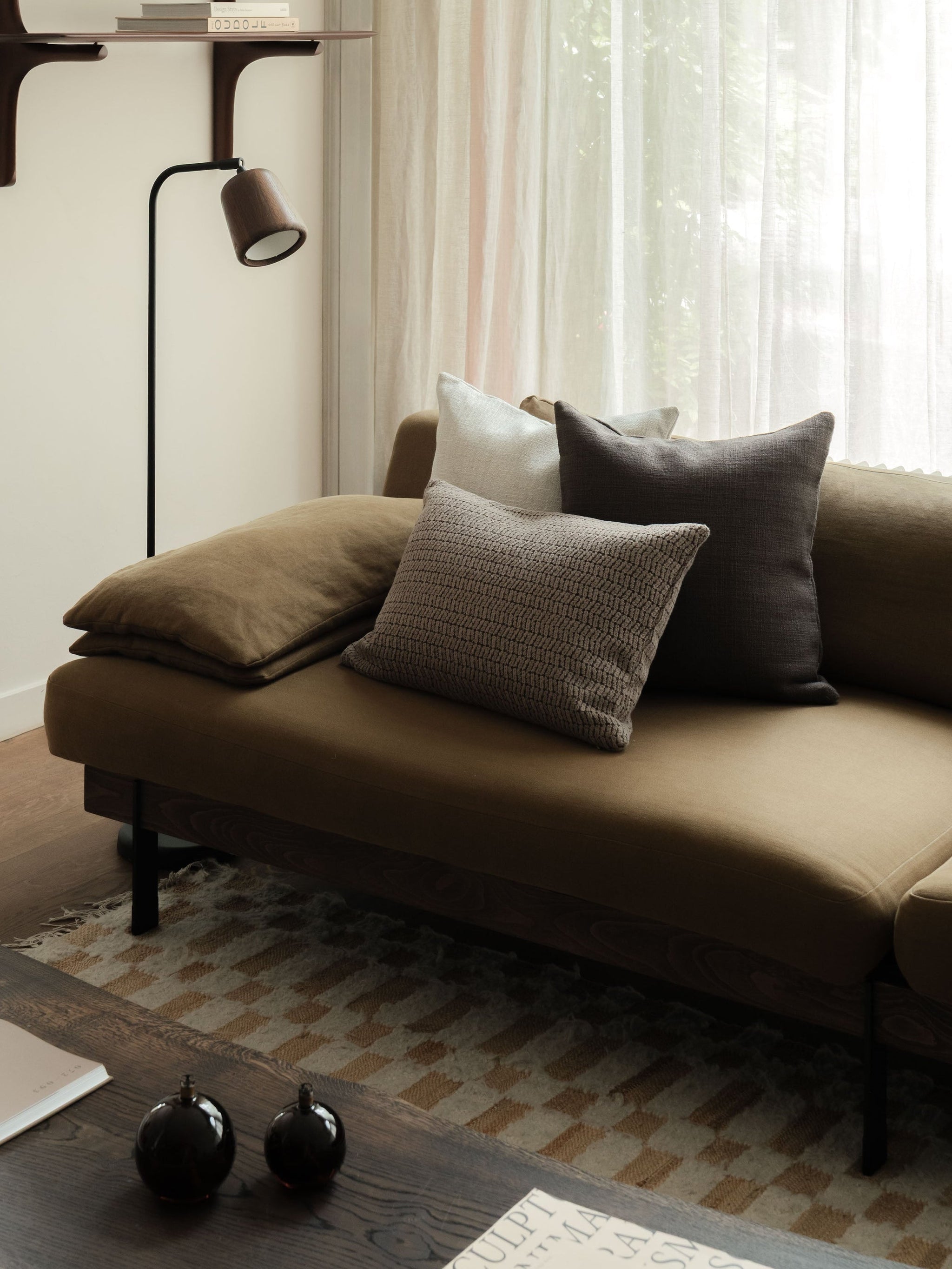 Dark Detail – The Asymmetric Trio, featuring three textured cushions in deep neutral tones, styled on a dark sofa