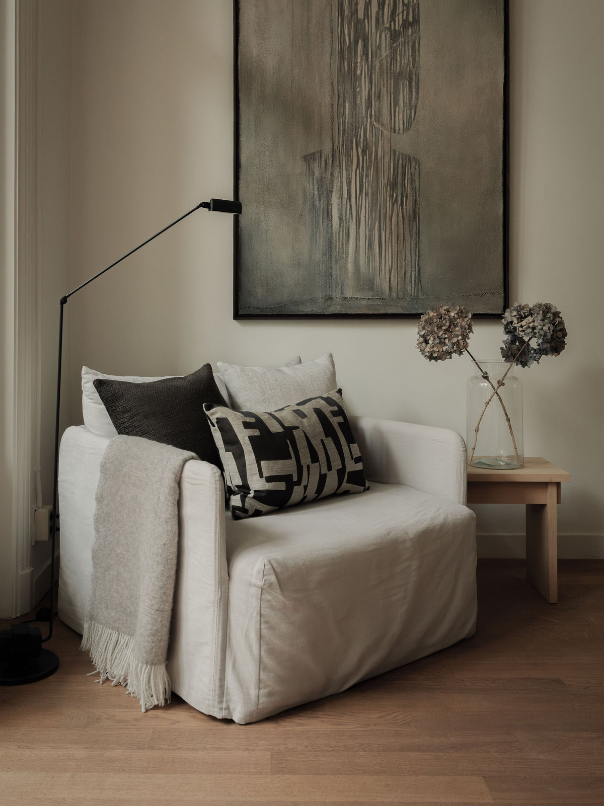 Warm Contrast – The Asymmetric Trio, featuring three cushions in warm neutral tones with contrasting textures, styled on a white armchair