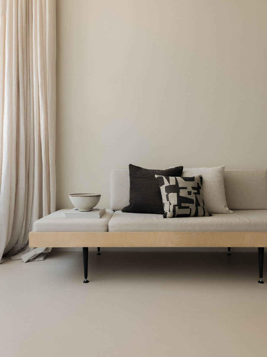 Warm Contrast – The Square Trio, featuring three cushions in warm neutral tones with contrasting textures, styled on a white sofa with a wooden frame