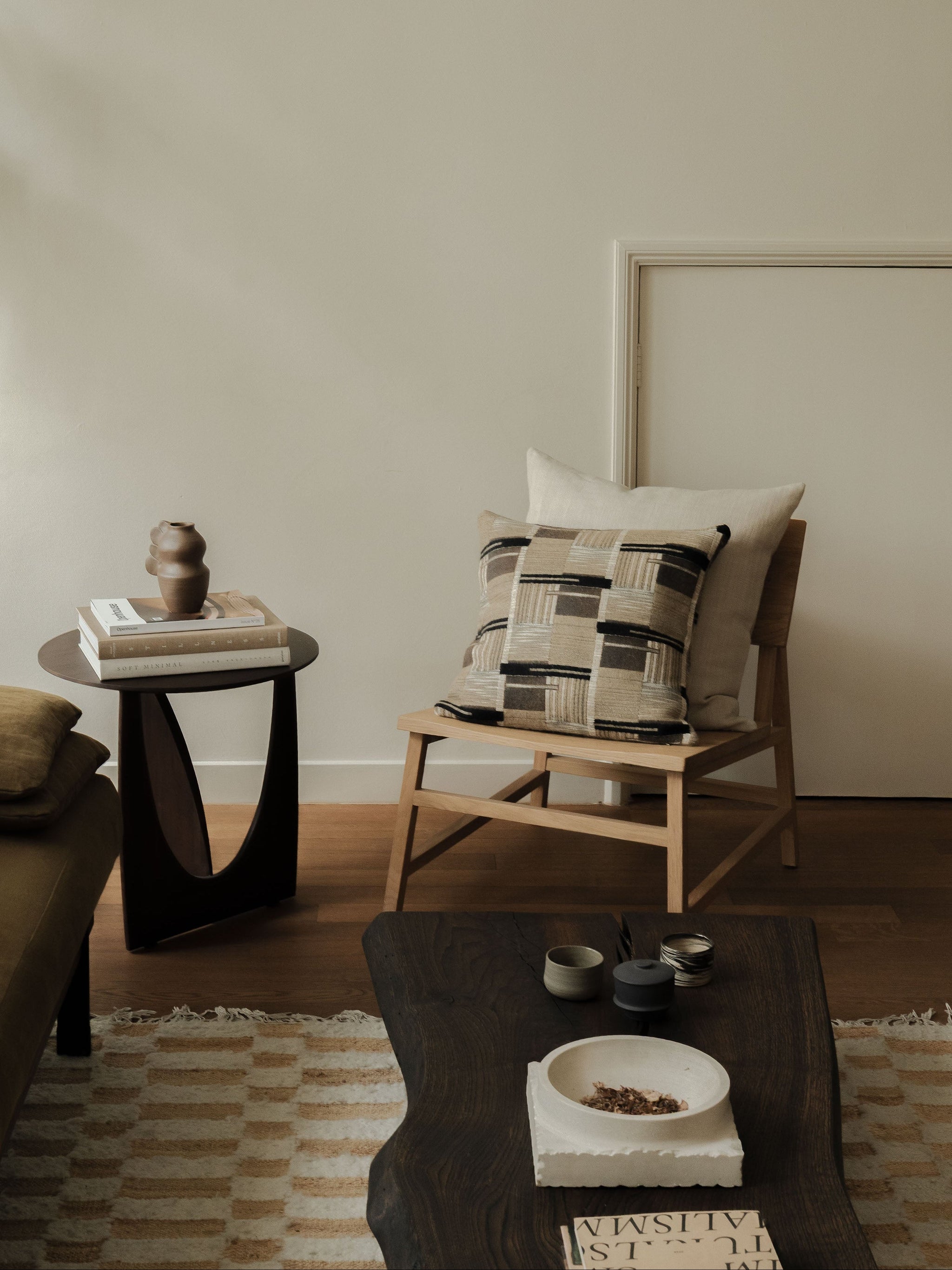 Soft Geometry cushion set in warm neutral tones, styled on a wooden chair in a calm interior setting
