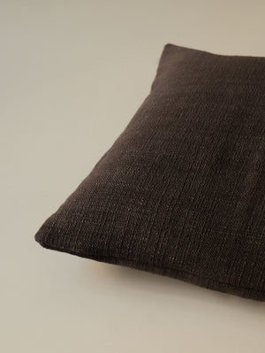 Close-up of the corner of the Atelier Moderne – Fondente cushion, highlighting the textured linen fabric and refined finish