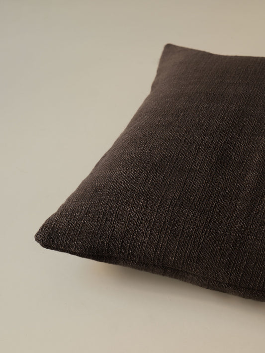 Close-up of the corner of the Atelier Moderne – Fondente cushion, highlighting the textured linen fabric and refined finish