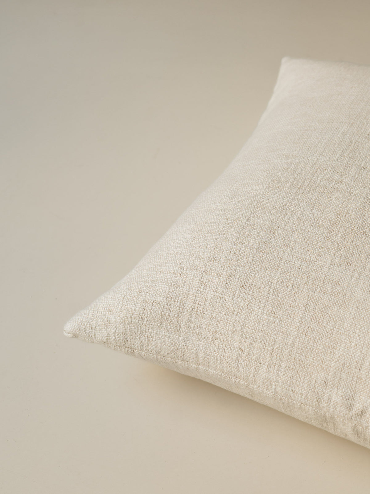 Close-up of the corner of the Mélange Moderne – Calcare cushion, highlighting the textured weave and neatly finished seams