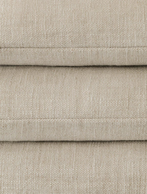 Close-up of a stack of three Mélange Moderne – Calcare cushions, highlighting the soft woven texture and subtle tonal variation