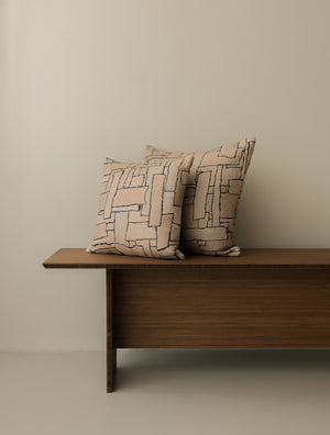 Naoki – Rose des Sables cushions in 40 × 40 cm and 50 × 50 cm, displayed together on a dark wooden bench