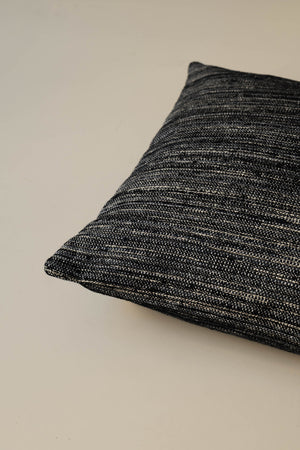 Close-up of the corner of the Roquebrune – Ebano cushion, highlighting the striped woven fabric and neatly finished seams