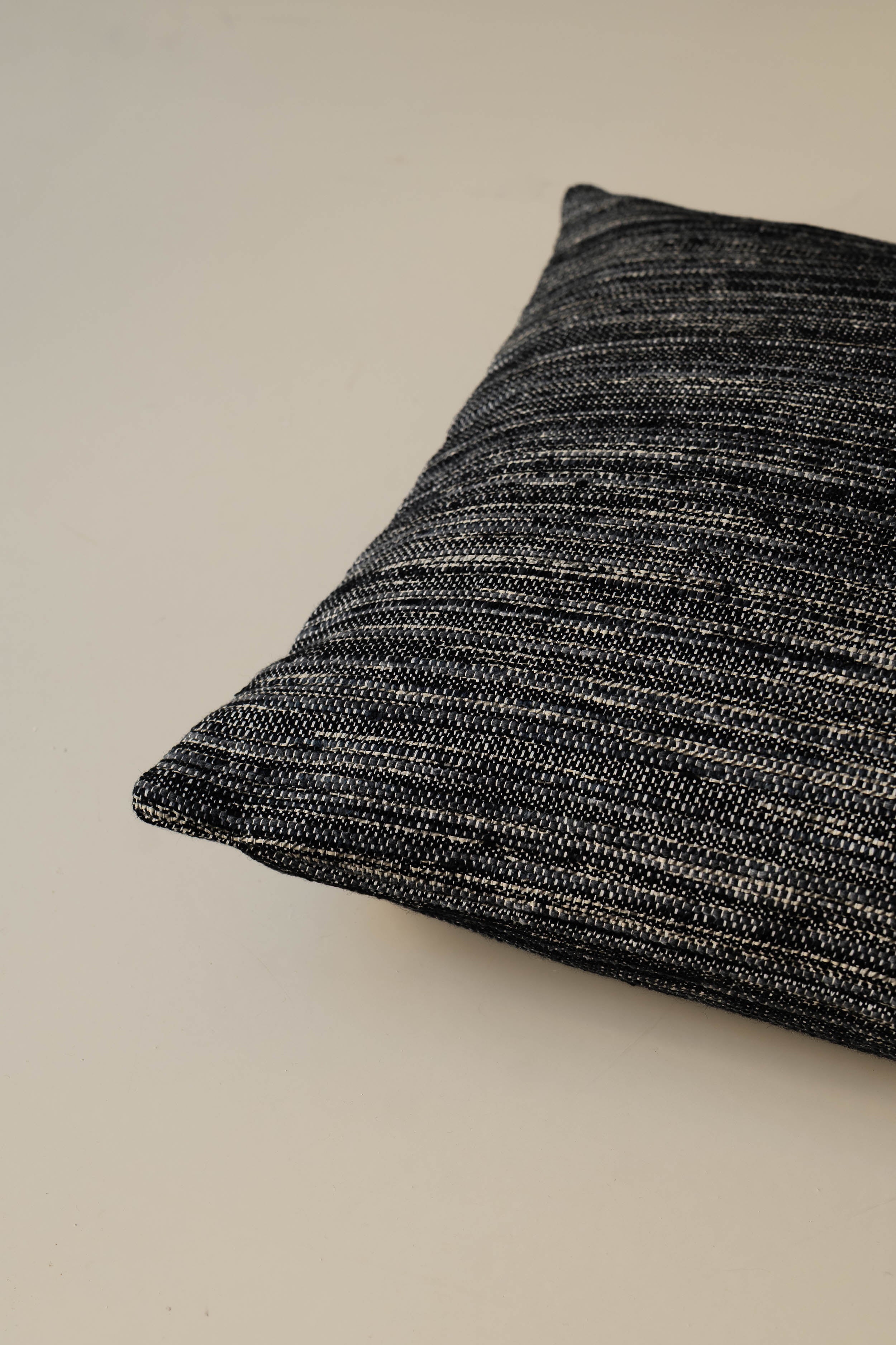 Close-up of the corner of the Roquebrune – Ebano cushion, highlighting the striped woven fabric and neatly finished seams