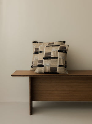 Yutaka – Bouleau cushions in 50 × 50 cm and 40 × 40 cm, displayed together on a dark wooden bench
